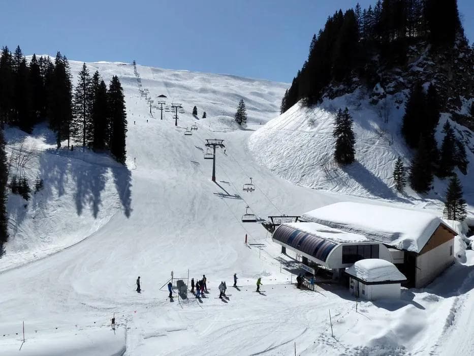 Ski resort chairlift carrying skiers and snowboarders up the mountain