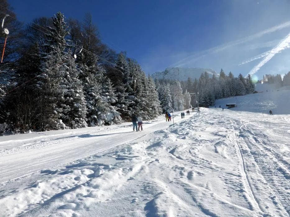 Ski resort chairlift carrying skiers and snowboarders up the mountain