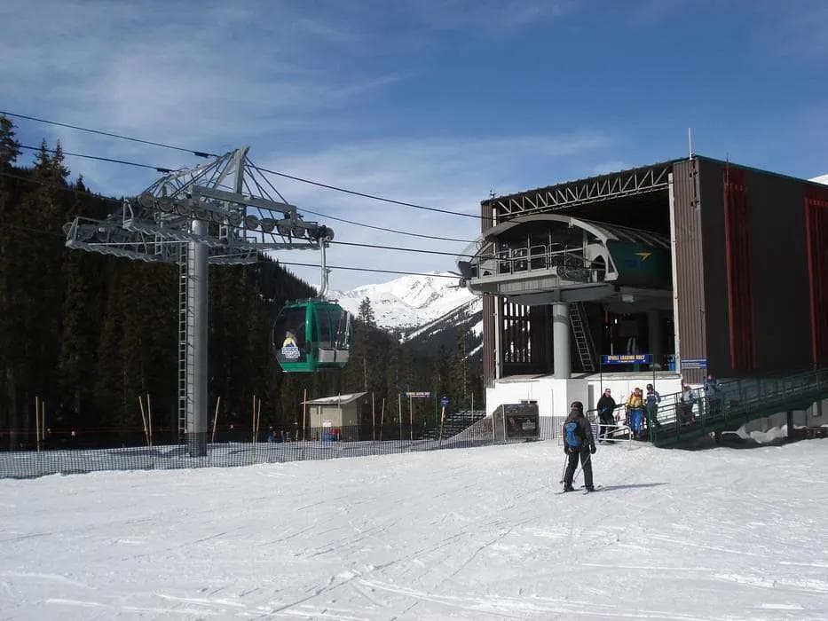 Ski resort chairlift carrying skiers and snowboarders up the mountain
