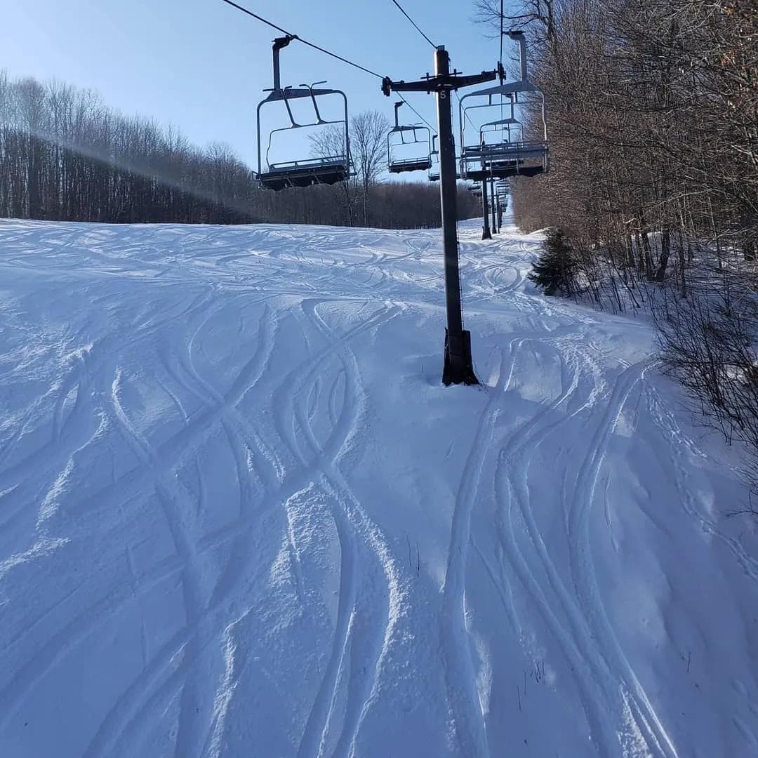 Ski resort chairlift carrying skiers and snowboarders up the mountain