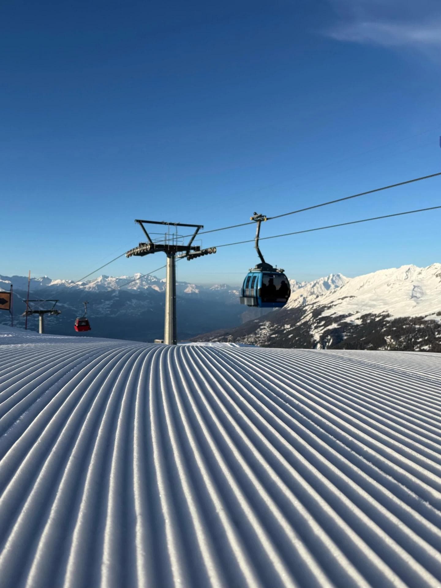 A gondola at Crans Montana on a perfectly groomed slope.