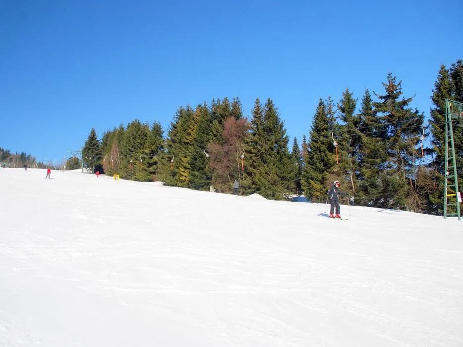 Ski resort chairlift carrying skiers and snowboarders up the mountain