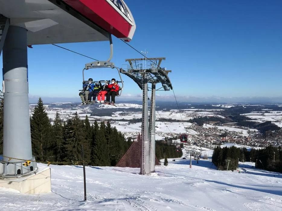 Ski resort chairlift carrying skiers and snowboarders up the mountain