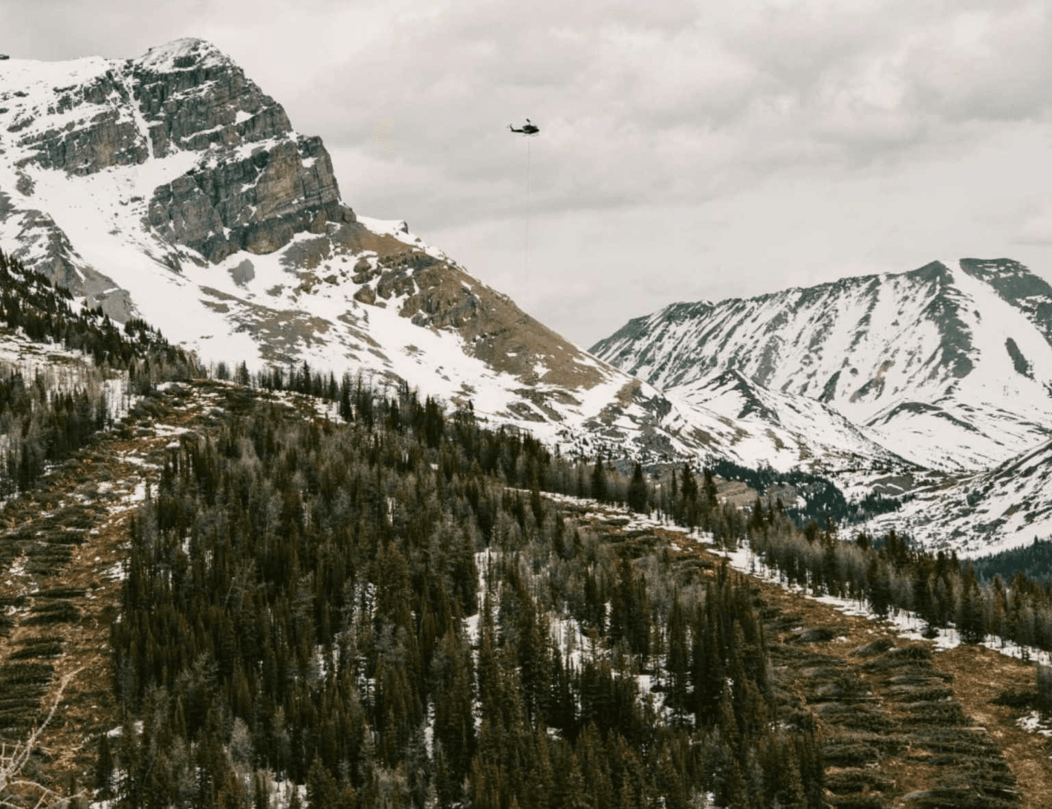 A helicopter helps with the installation of a new chairlift.